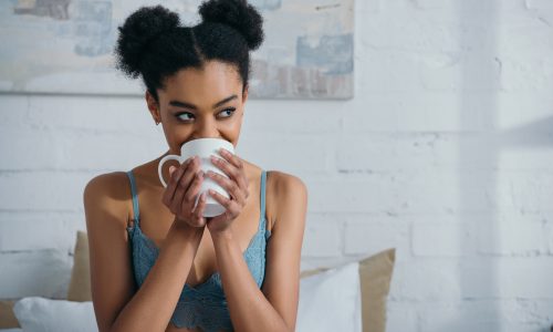 attractive smiling afro girl drinking coffee